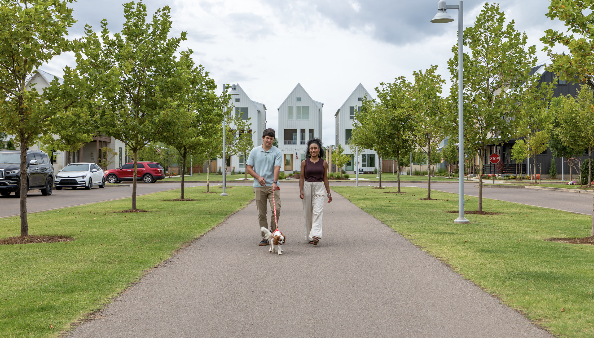 two people walking their dog down a paved path at The  Lindy at Wheeler
